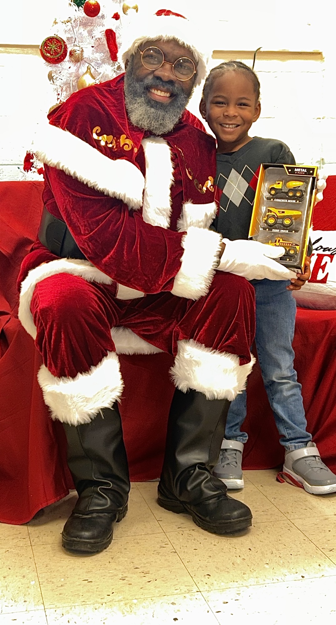 santa gifting a set of toy trucks to a young boy